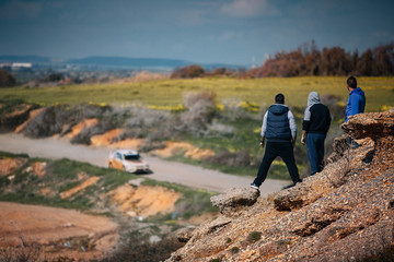 Spectators watching rally race from top ot the rock