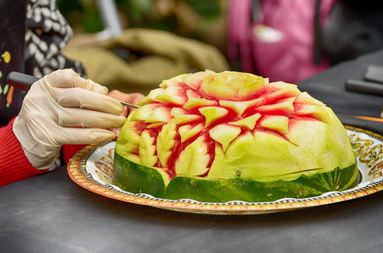 carving sculptures from watermelons.Artists create works of art.