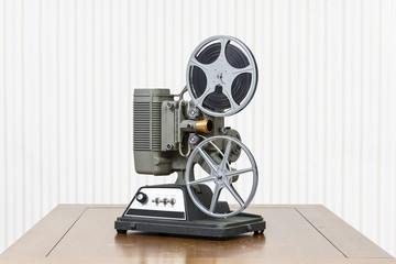 Antique 8mm home movie projector on wood table.
