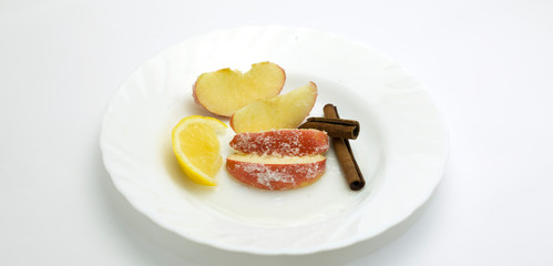 apples. cinnamon and walnuts on white background