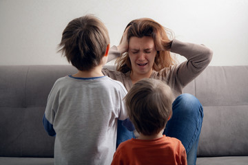  Woman mom is tired in depression and children are boys.