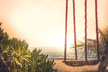 Travel lifestyle beach swing sea sunset palm trees sunlight island background vintage style copy...