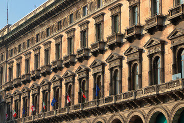 Fototapeta na wymiar Palazzo storico con bandiere a Milano in Italia, Historic palace with flags in Milan in Itly 