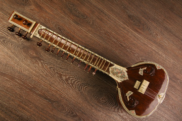 Indian musical instrument sitar lying on the wooden floor