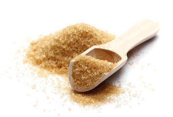 Brown cane sugar pile in wooden spoon isolated on white background, sugarcane texture