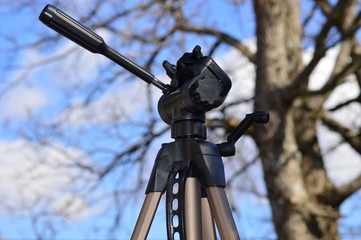 A Tripod in the blue sky with forest background      