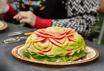carving sculptures from watermelons.Artists create works of art.