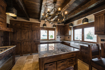 Wooden ceiling, retro chandelier and countertop in kitchen inteior