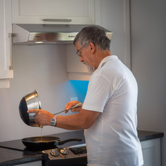 Senior man cooking in his modern kitchen