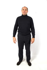 A young man dressed in black jeans and a black shirt standing on white background