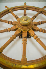 Vintage old wooden ship steering wheel in the public naval museum. Wooden helm of the old battleship.