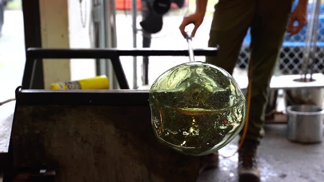 A glass blower shaping a piece of art
