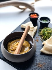 Hummus in a clay pot with pesto sauce and tomato salsa. High resolution picture perfect for cooking book, receipt book or food magazine.