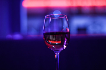 Cocktails A glass of wine. A beer rack with drinks. Night lighting of the institution. Purple Scythian in the background. Cafe. Bar.