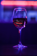 Cocktails A glass of wine. A beer rack with drinks. Night lighting of the institution. Purple Scythian in the background. Cafe. Bar.