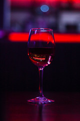 Cocktails A glass of wine. A beer rack with drinks. Night lighting of the institution. Purple Scythian in the background. Cafe. Bar.