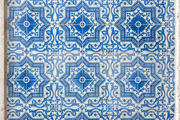 Old wall with traditional Portuguese decor tiles azulezhu in blue tones.