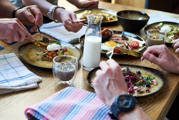 Friends group having english breakfast at cafe restaurant, close-up.