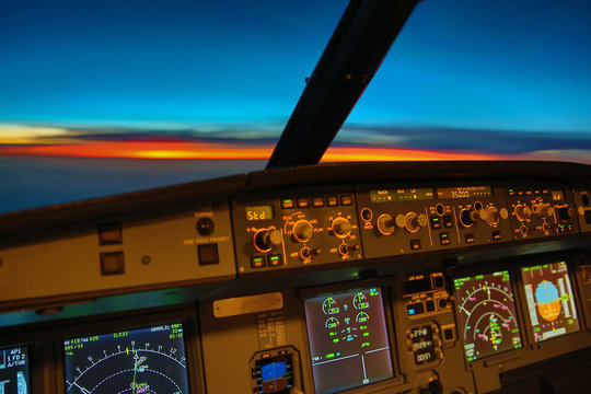 early morning sunrise - captains view in the flight deck of a modern airliner airplane 
