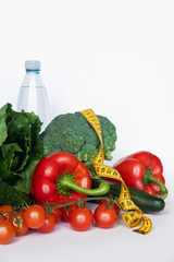 vegetables and water with tape line on white background. Healthy food concept. Copy space