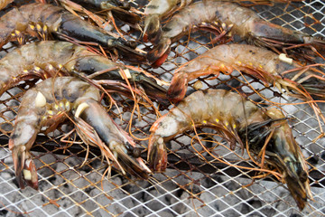 Roasted prawns on metal baking sheet background close up