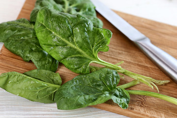 Fresh spinach leaves on a board close up