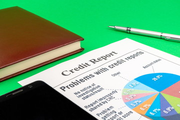 Credit report on the green table and a pen.