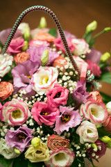 bouquet of flowers in a wooden box. multi-colored roses and wild white flowers