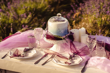 festively served table with lavender bouquets, cake and wedding concept