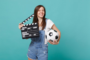 Joyful woman football fan support favorite team with soccer ball, classic black film making clapperboard isolated on blue turquoise background. People emotions, sport family leisure lifestyle concept.