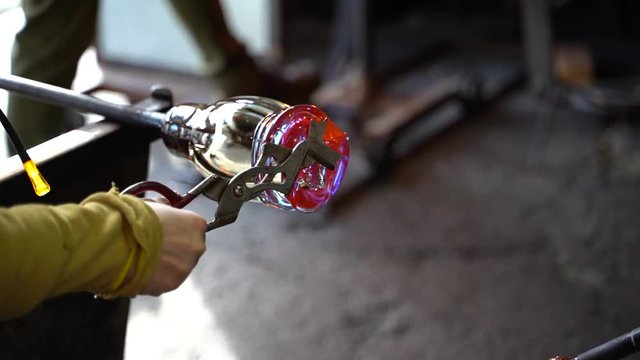 A glass blower shaping hot glass