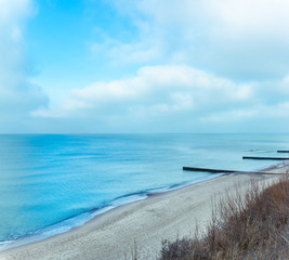 coast of blue sea with sandy beach on a cloudy day