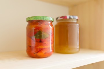 Storage cabinet in kitchen, storage with wooden shelves with food. Shelves of homemade canned vegetables preserves