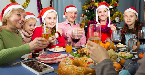 Fototapeta na wymiar Happy family is celebrating New Year together and drinking