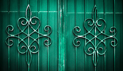 .Wrought iron gate flower like custom made ornament on dark green metal plate