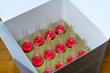 ampoules with a red preparation. The concept of a virus, antivirus, biological weapons, the danger to human and animal health. Selective focus