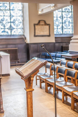 Holy Bible on a stand in the church in front of the priest. Empty church with focus on Bible