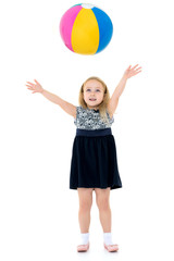 Little girl is playing with a ball