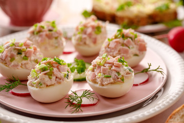 Deviled eggs, stuffed eggs filled with a paste made from smoked ham, mayonnaise, egg yolks and fresh chive on a plate.Tasty breakfast, appetizer for party or holiday meals