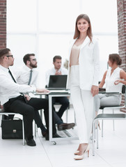 Obraz premium young business woman standing near desktop