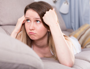 Young female is thoughtful and bored alone
