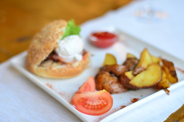 fried potatoes sliced with burger and poached egg with sauce