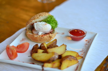 fried potatoes sliced with burger and poached egg with sauce