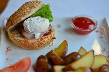 fried potatoes sliced with burger and poached egg with sauce