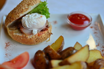 fried potatoes sliced with burger and poached egg with sauce