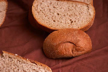 bread on dark wooden table and brown napkin. Bread slices and crumbs viewed from above. Top view