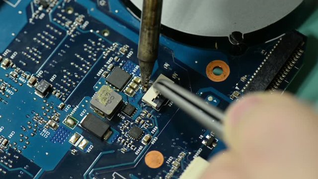 Repair computer circuit board: soldering connector on the laptop motherboard.