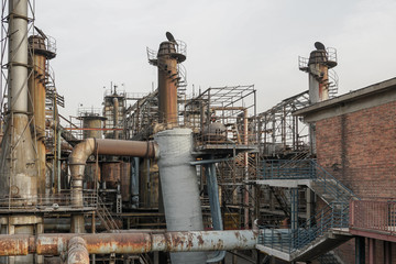 Old Factory metal structures. Industrial plant with old, rusty pipes and cooling tower for cooling water supply. Beijing, China.