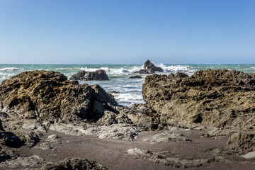 Ocean and a sandy beach with rocks