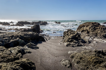 Ocean and a sandy beach with rocks